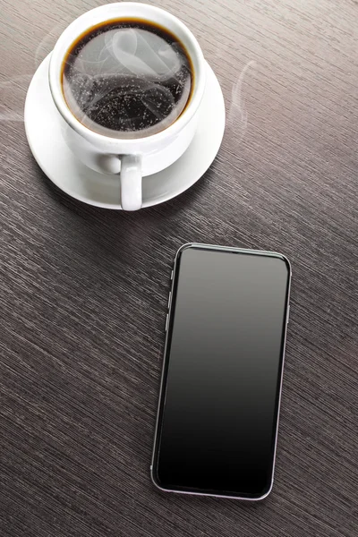 Une tasse de cappuccino décoré et téléphone intelligent — Photo