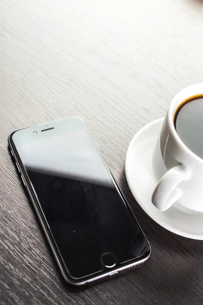 Egy csésze díszített cappuccino és szúró telefon — Stock Fotó