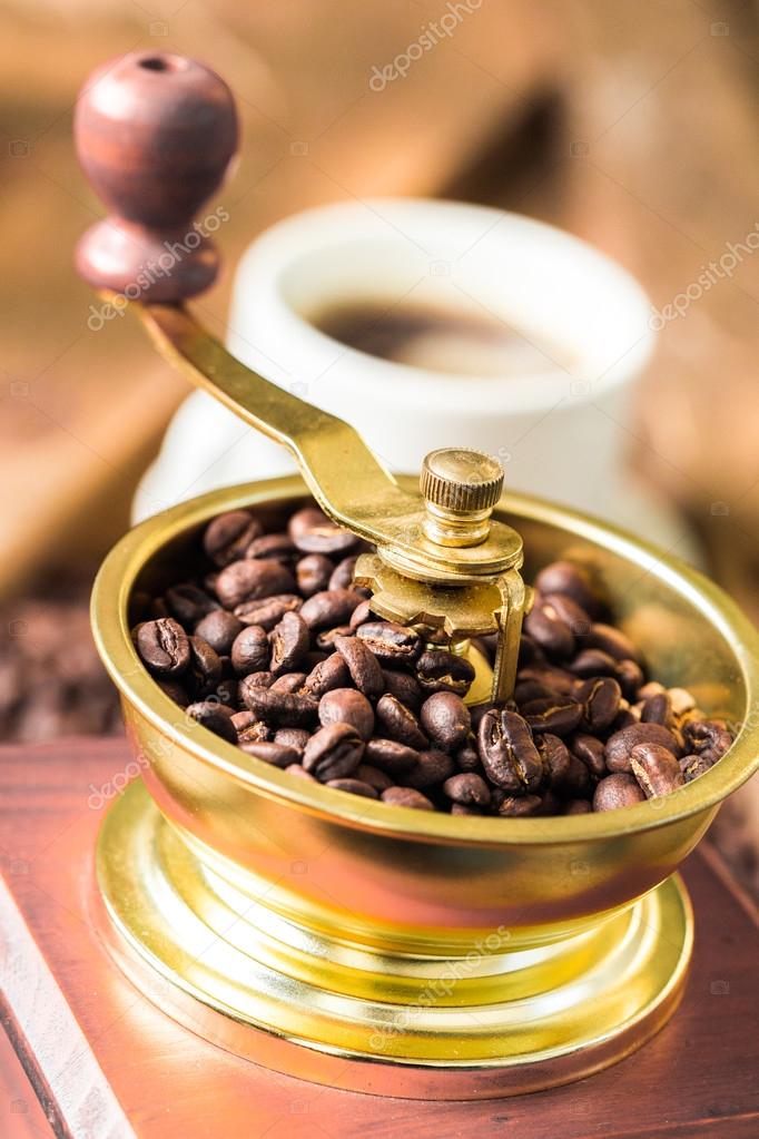 Cup of steaming hot coffee with coffee beans, coffee grinder, and coffee beans bag