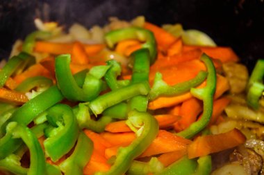 Taze yeşil biber dilimleri ve havuç ve et. Sebzeli sıcak et