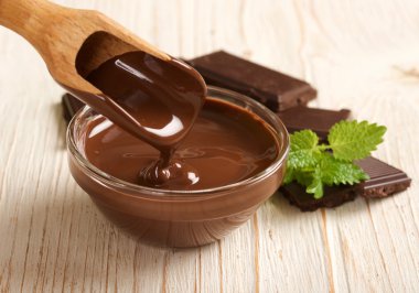 ahşap arka plan üzerinde eritilmiş çikolata