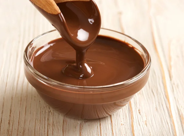 Melted chocolate on a wooden background — Stock Photo, Image