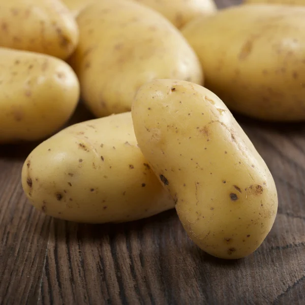 Batatas em um fundo de madeira — Fotografia de Stock