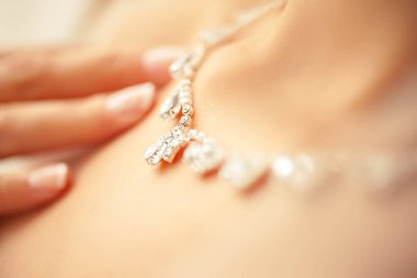 Kolyeye dokunan kadın eli. Odaklanma konseptini kapat.