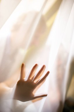 Birbirine aşık bir çiftin arka planına uzanan parmaklarını organzanın altına yaymış bir adamın avuç içi silueti. Odaklanma kavramı.