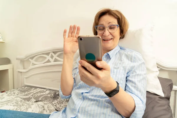 안경을 비디오 통화를 하면서 행복하게 실내에서 인사말을 나이든 — 스톡 사진