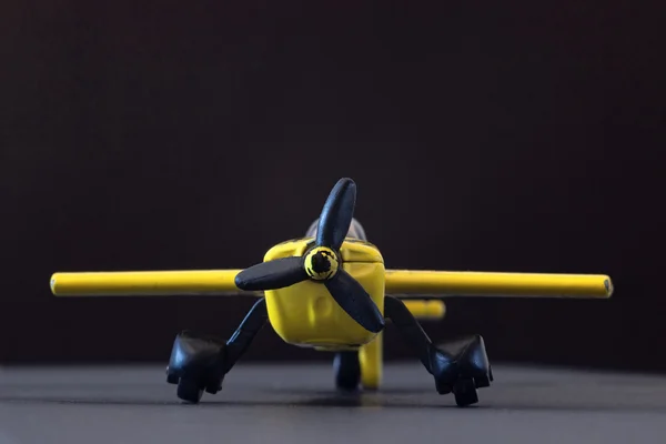 Жовтий іграшковий літак на чорному фоні — стокове фото