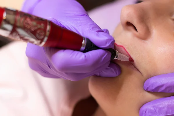 Cosmetólogo aplicando maquillaje permanente en los labios Enfoque selectivo y poco profundo Profundidad de campo — Foto de Stock