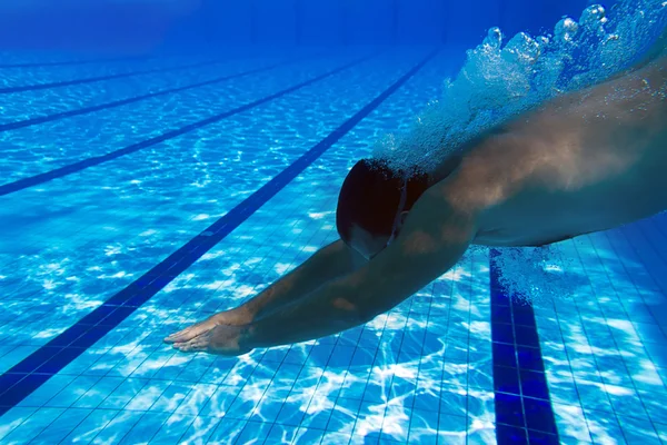 Saltando para a piscina subaquática. Nadador masculino na piscina. Foto subaquática . — Fotografia de Stock