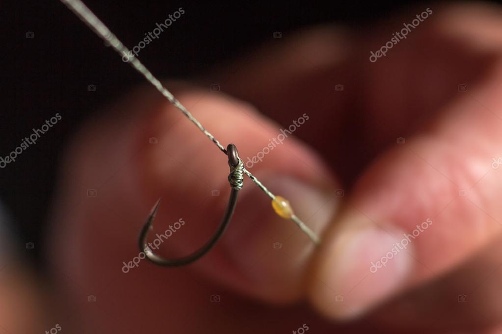 Man hand tying a fishing hook. Tie the KD rig. Selective focus. Tie Hook  Close Up.