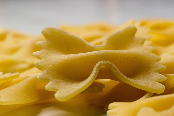 나비 넥타이 파스타 닫습니다. Farfalle 파스타입니다. Farfalle 리본 이탈리아 파스타. Farfalle-나비 모양의 파스타 배경. — 스톡 사진