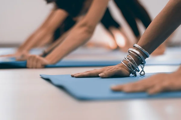 Joven mujer moderna haciendo ejercicios de yoga estiramiento. Mujeres manos en el yoga se reunieron . —  Fotos de Stock