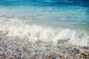 Kumlu sahilde yumuşak bir mavi okyanus dalgası