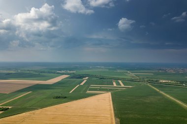 Tarım alanlarının havadan görünüşü. Bulutlu kırsal alan, hava manzarası.