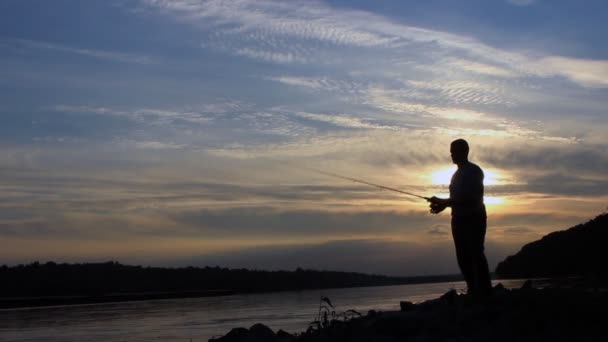 Σιλουέτα του ψαρά στο ηλιοβασίλεμα, χυσιμο ψαράς — Αρχείο Βίντεο