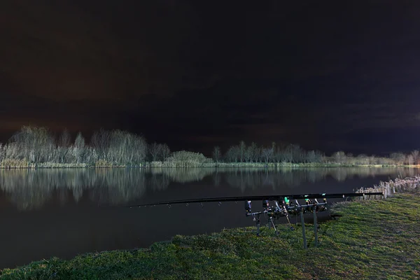 Nachtfischen, Karpfenruten, Spiegelung des Nachthimmels am See — Stockfoto