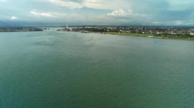 Portsmouth Limanı 'nın üzerinde, Birleşik Krallık' ın Portsmouth kentindeki Spinnaker Kulesi 'nin uzak görüntüsüyle uçuyor. hava durumu