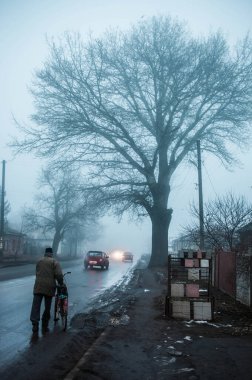  Bisikletli bir adam sokakta yürüyor. 