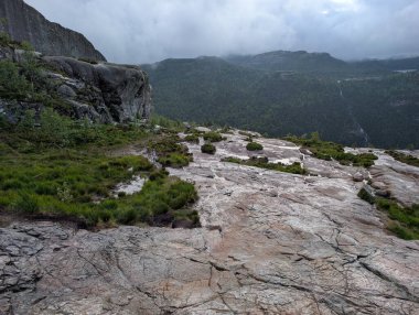 Kayalıkları ve ormanı bulutlu gökyüzünün altında kayalık dağ platosu.