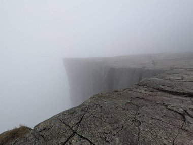 Yoğun siste kaybolan kayalık kenar..