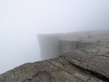 Kayalık yüzeyi ve düşük görüş mesafesi olan sisli dağ yamacı..