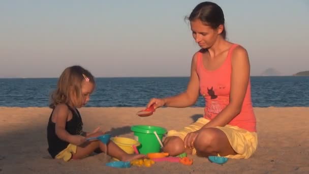 Mutter und Tochter spielen. sie klopfen auf den Schaufeleimer und lachen. — Stockvideo