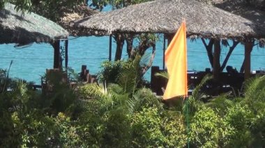 Rüzgarda çırpınan turuncu boş bayrak. Tropics. Asya.