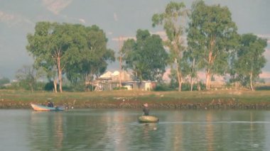 Vietnamca küçük sepet tekne yüzen Nehri üzerinde yuvarlak. iki adet bot. Beyaz leylek.