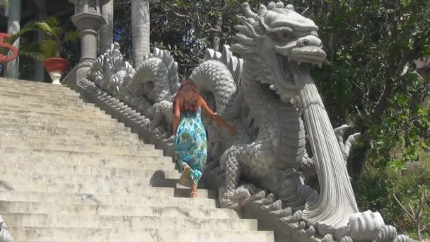 Mädchen steigt die Treppe hinauf. Treppe mit Drachenstatuen dekoriert — Stockvideo