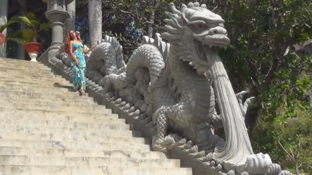 Mädchen steigt die Treppe hinauf. Treppe mit Drachenstatuen dekoriert — Stockvideo