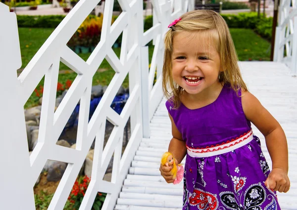 little girl laughing.  she goes over the white bridge