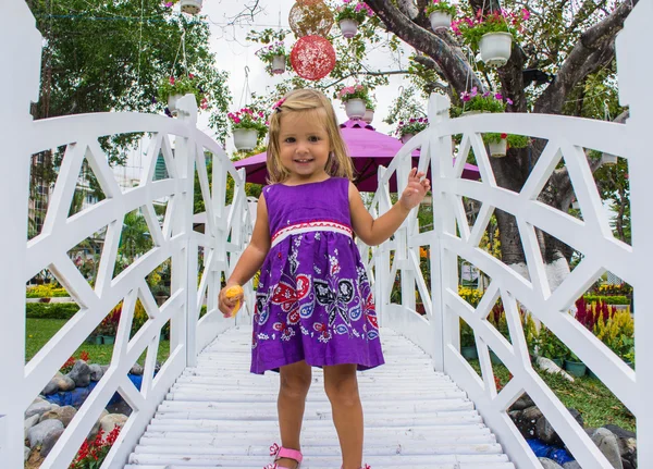 little girl laughing.  she goes over the white bridge