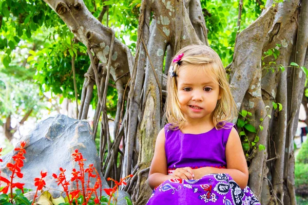 Malá holčička v tropické zahradě. bonsaje strom — Stock fotografie