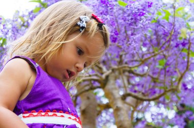 Mor ahşap arka plan üzerinde küçük kız