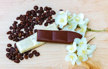 Beyaz ve sütlü çikolata parçaları. Yasemin çiçekleri. Sade kahve
