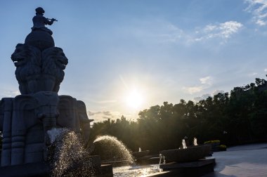 Çeşme, topa oturan çocuk ve flüt çalmaya, su kaçar mayo filler dan