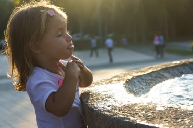 Çeşme ellerini yıkama güzel küçük bir kız. Sunset Bulvarında. ciddi düşünceli yüz.