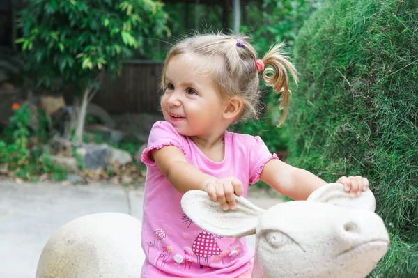 Malá holčička jezdí hračka jelen — Stock fotografie
