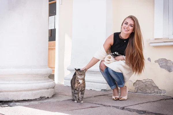 Moda di bella bella giovane donna hipster che gioca con un gatto, si chinò verso il basso, capelli volanti . — Foto Stock