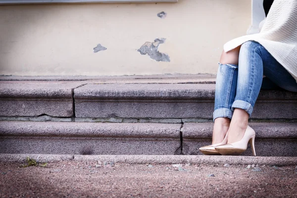 Piernas femeninas en un hermoso melocotón zapatos de tacón alto con nariz de oro. Primer plano. manos vaqueros corregidos . — Foto de Stock
