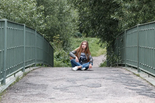 Молодая красивая девочка-подросток сидит на треке на мосту, рок-н-ролл. рок стиль . — стоковое фото