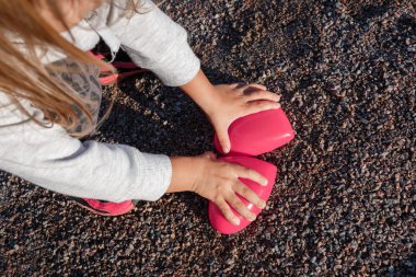 küçük kız bir kırmızı plastik kalp ile. o onun elinde tutan