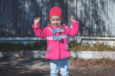 Pembe bir ceket, kot pantolon ve parkta yürüyüş botları, küçük kız