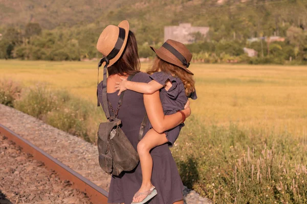 Mère avec la fille aller sur les rails, retour à une caméra, sur la nature, en été — Photo