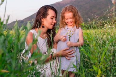 Genç anne ve kızı pirinç tarlası, doğa ve seyahat yakınında kucaklaşırlar.