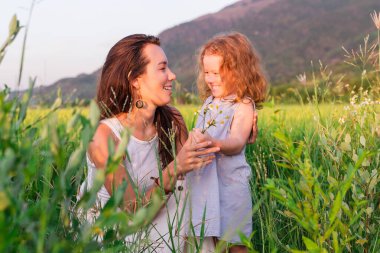 Genç anne ve kızı pirinç tarlası, doğa ve seyahat yakınında kucaklaşırlar.