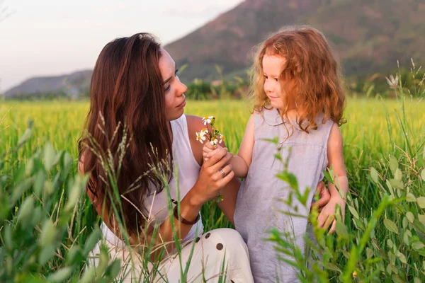 Jovem mãe e daugther olhar sobre a flor perto de campo de arroz, natureza, viajar — Fotografia de Stock