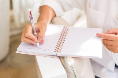 İş kadını defterine bir not yazmış. Kalem elimde.