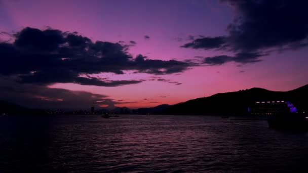 Vakker rosa solnedgang over fjellene i bakgrunnen av havet – stockvideo