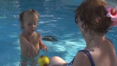 Havuzu bebek atar bir sarı topu güzel genç büyükannesi, onlar gülmek ve oyun.